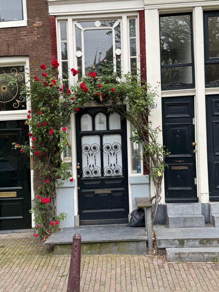 Red flower arch over a canal house doorway
